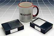Picosatellites, less than one-half pound each, are shown against a coffee mug.